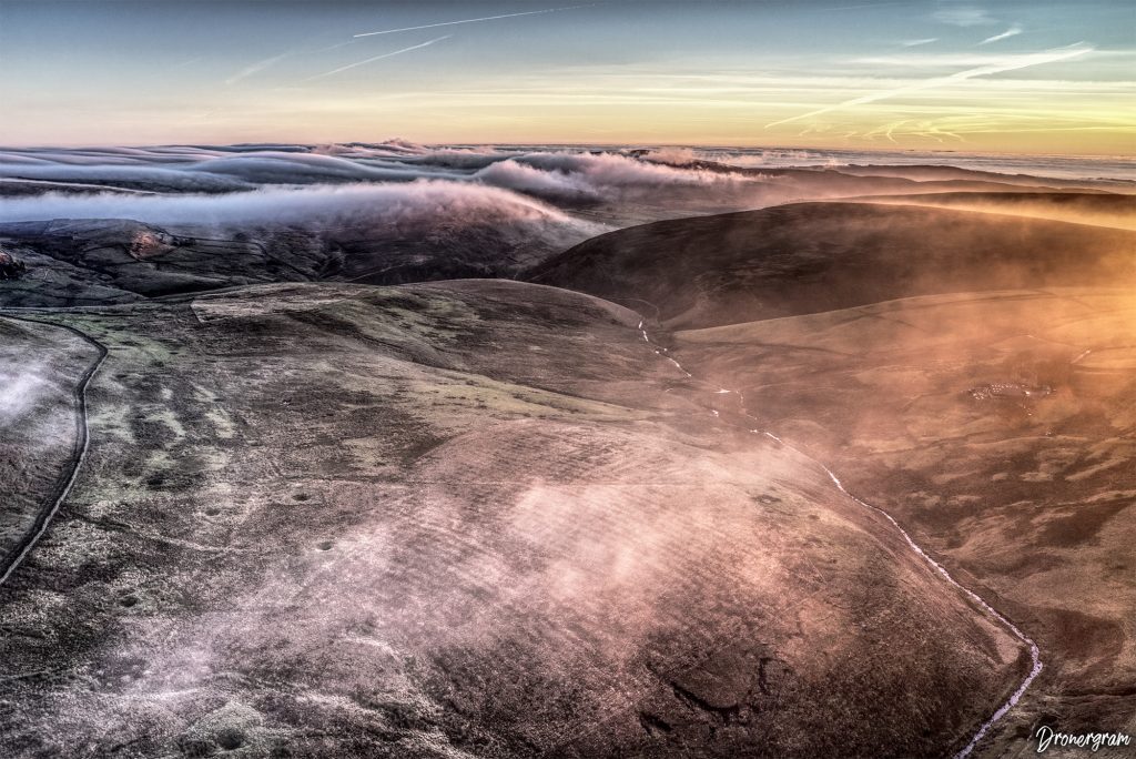 Aerial drone imagery of a mystical misty rolling landscape.